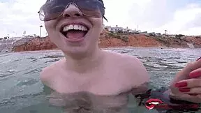 A ‘dick tease’ teenage girl with huge natural bust fondles a guy’s cock on a beach