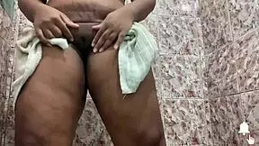 The attractive woman with brown hair show off her body in a restroom