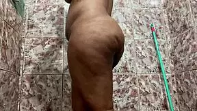 The attractive woman with brown hair show off her body in a restroom