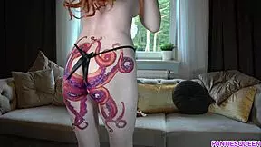 A young woman in her brand with an octopus tattoo on her buttocks tries various underclothes while nude