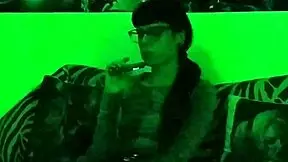 Beth kinky - smoking a cigarette in green light, wearing goth sex gear